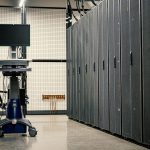Contemporary computer on support between telecommunication racks and cabinets in modern data center
